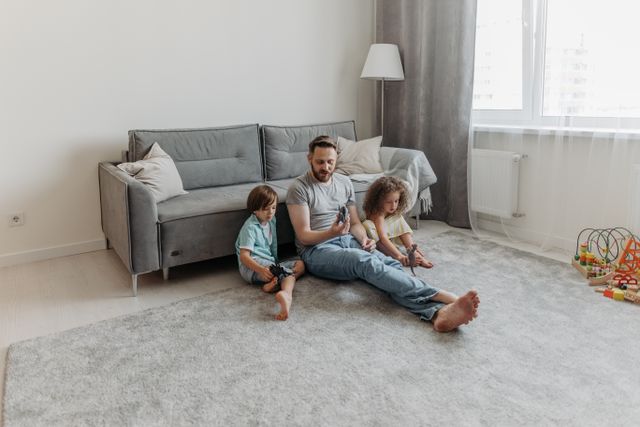 Father and two children enjoy playtime in the living room. Warm family bonding moment captured indoors.
